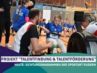 Paul Heinrich (li.), Landestrainer der Sportart Rudern, erklärt einem Kind im Rahmen der diesjährigen Sachsen-Anhalt-Spiele den Umgang mit dem Ruder-Ergometer