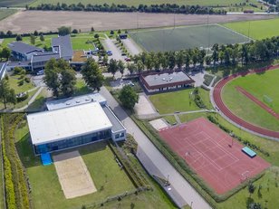Luftaufnahme der Außensportanlagen der Landessportschule. Man sieht die Rasenplätze, die Schwimmhalle mit Beachvolleyballplatz, Tartanplätze und die Sporthalle