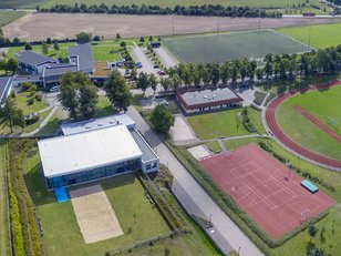 Luftaufnahme der Außensportanlagen der Landessportschule. Man sieht die Rasenplätze, die Schwimmhalle mit Beachvolleyballplatz, Tartanplätze und die Sporthalle