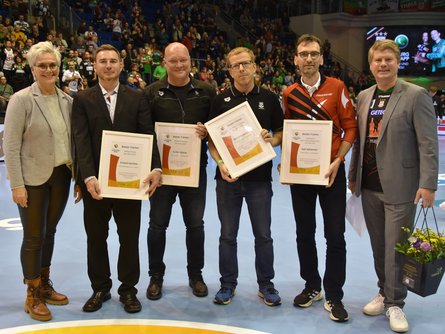 LSB-Präsidentin Silke Renk-Lange (li.) und Vorstandsvorsitzender Tobias Knoch (re.) ehren die vier Trainer des Jahres 2023. 
